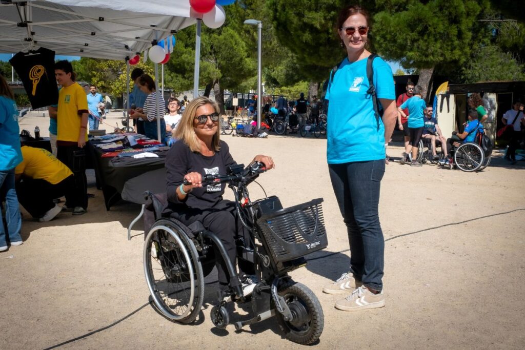 Teresa Silva, a wheelchair user, using her Batec handbike with a colleague at a Fundación También event.