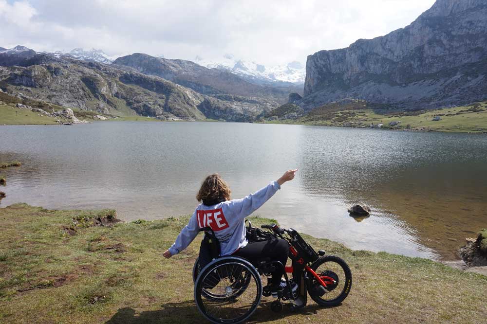 handbike batec eléctrico. De silla manual a silla de ruedas eléctrica. Chica en silla de ruedas con un handbike Batec eléctrico disfrutando de la naturaleza. De silla manual a silla de ruedas eléctrica.