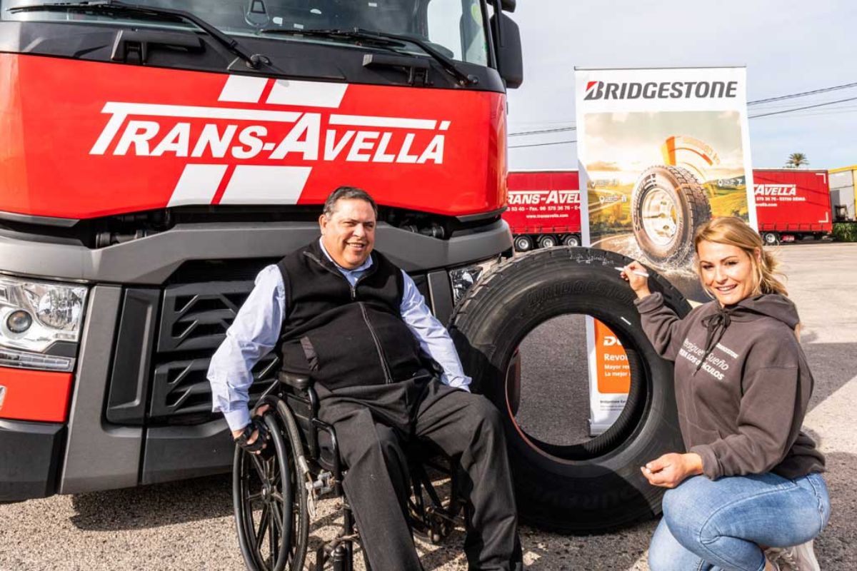 A man in front of a truck with his wheelchair.